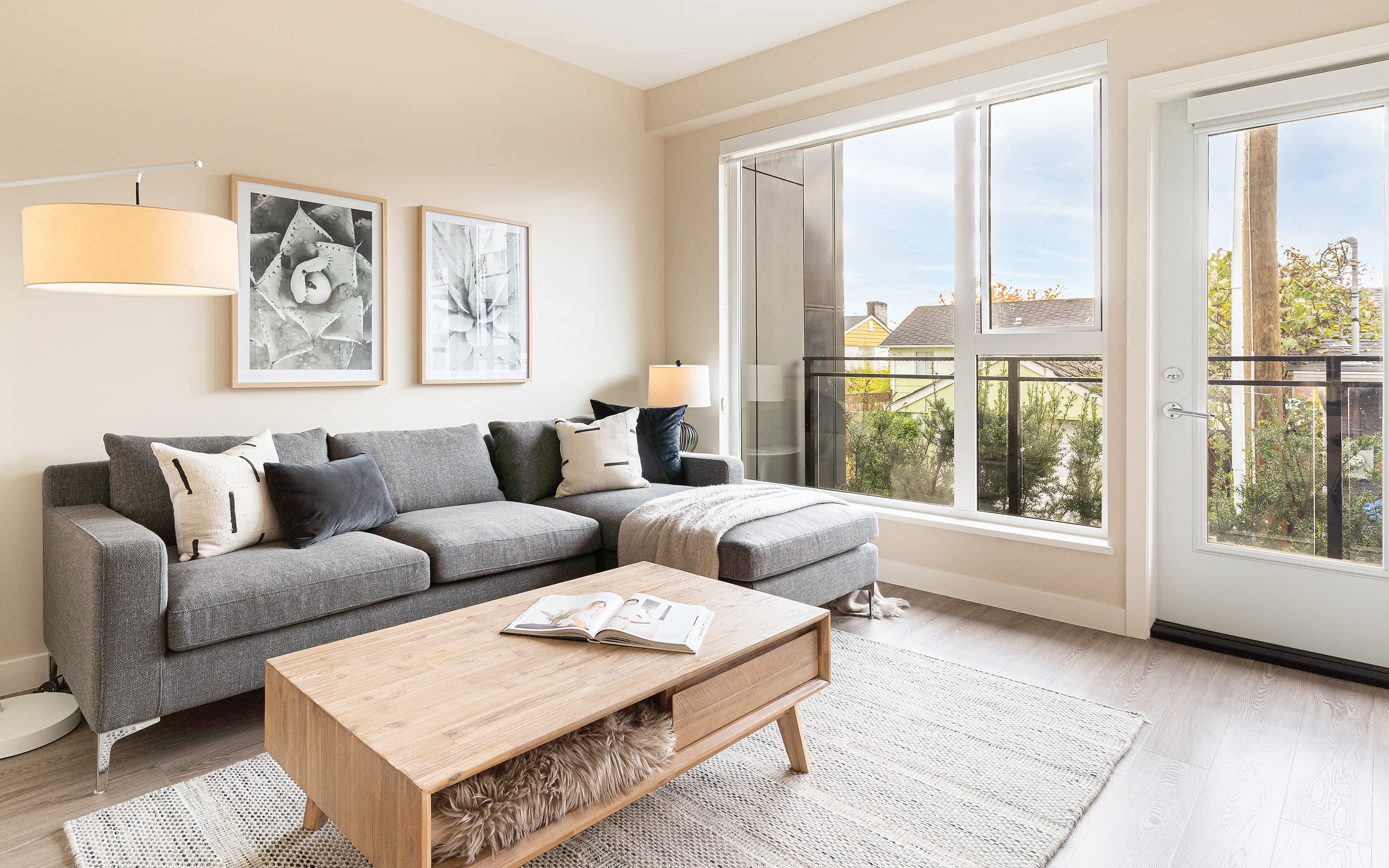 A furnished living room at Aria with large windows over the Oakridge neighbourhood